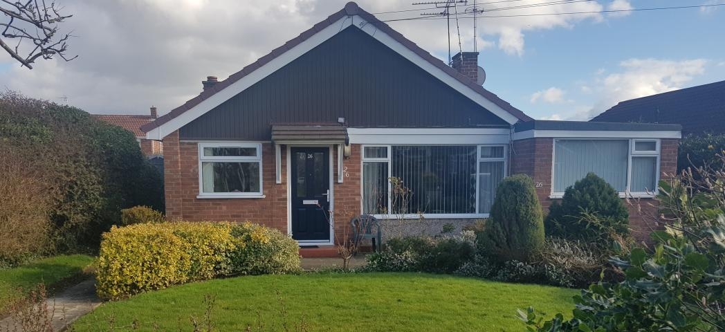 Peaceful bungalow property in Gleneagles Close with single storey extension to the right of the building. Behind a well-kept front garden and curved pathway.