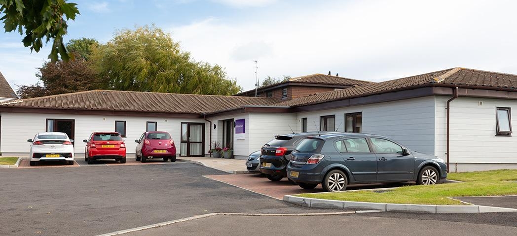 White wood panelled, single storey exterior at the residential care home Shaftesbury Court.