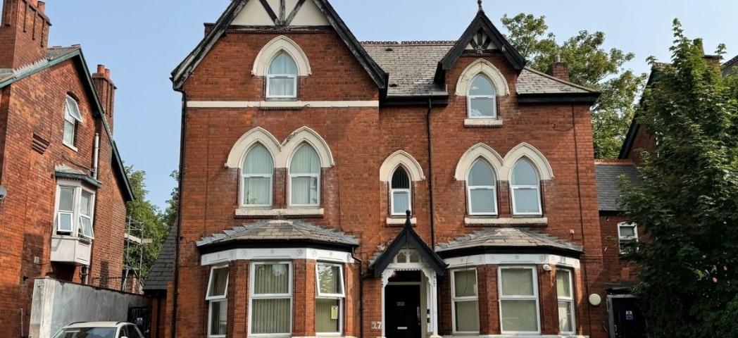 Exterior view of Sandwood House, a red brick supported accommodation property with period architectural features.