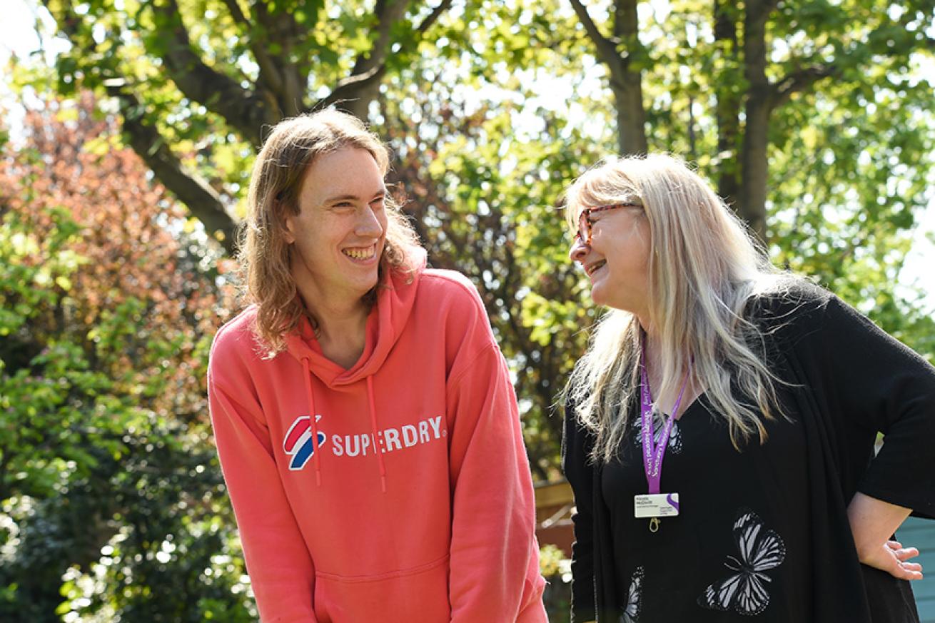 Customer and staff member smiling out in the gardens
