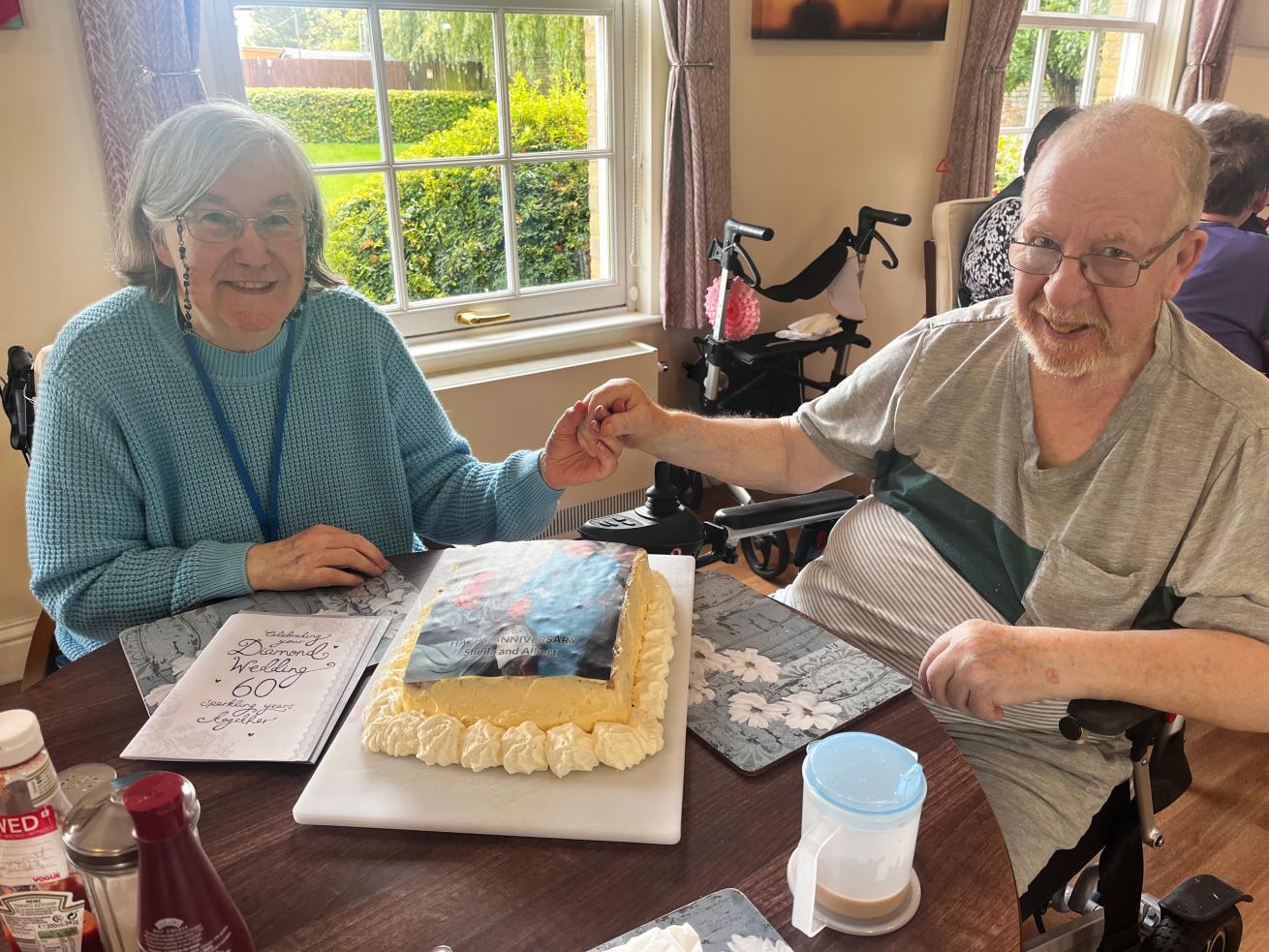 A couple who have been married for 60 years sat together in their retirement home and smiling
