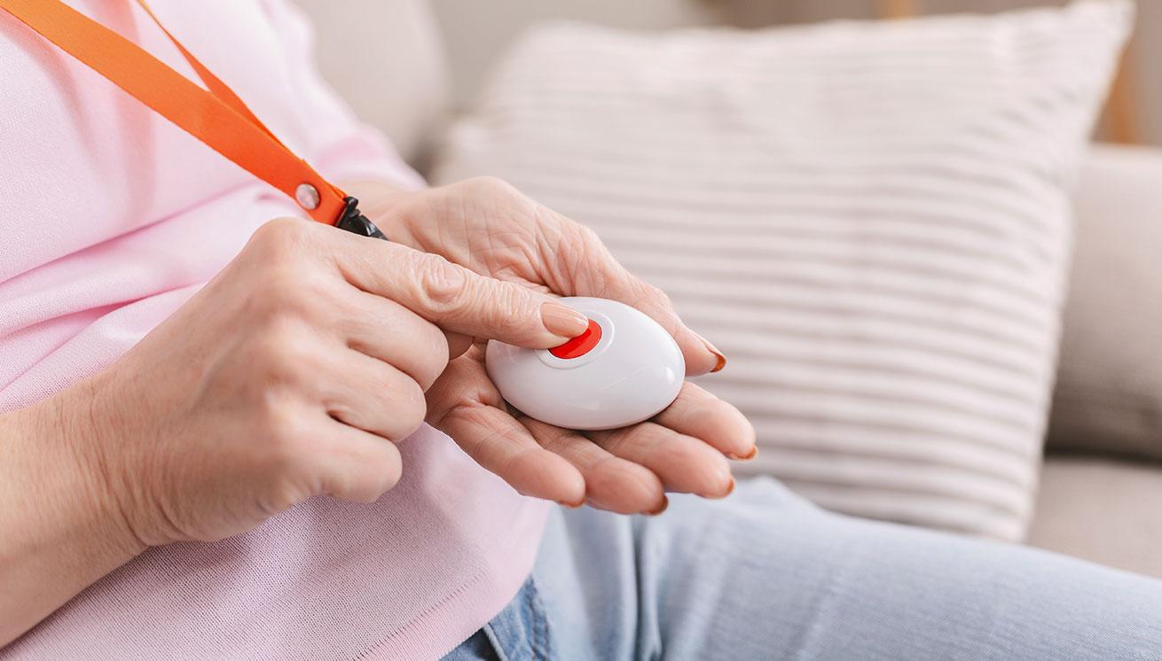 Woman pushing pendant alarm button to call for assistance