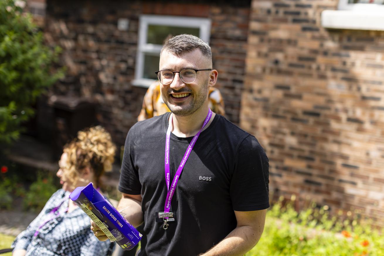 A Sanctuary worker walking towards the camera with a smile on his face