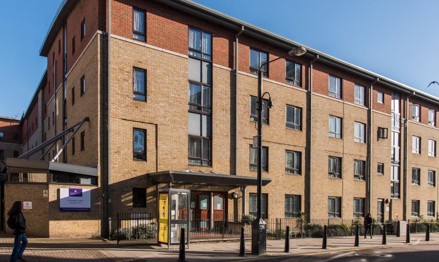 A four storey new-build brick apartment block, located by a main road with gated access to the entrance and a secure gated carpark. 