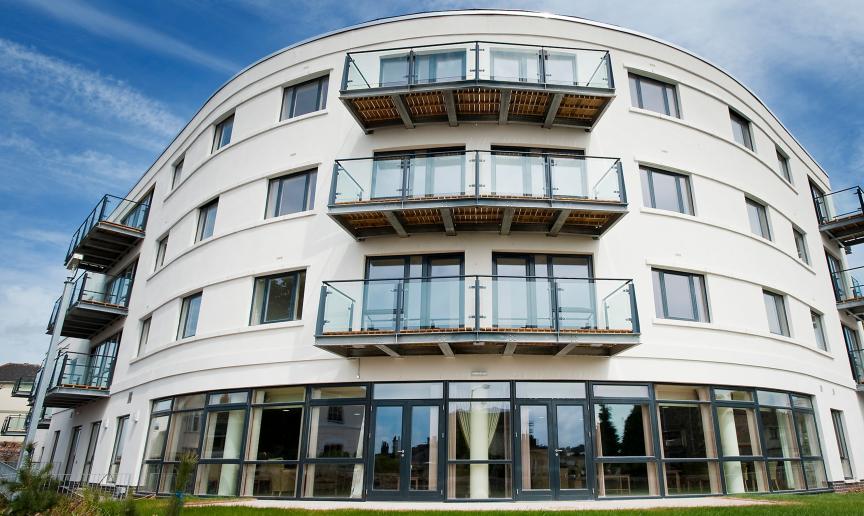 Uniquely curved retirement living property. The building features an array of oversized windows and french doors as well as personal balconies for a bit of personal outdoor space.