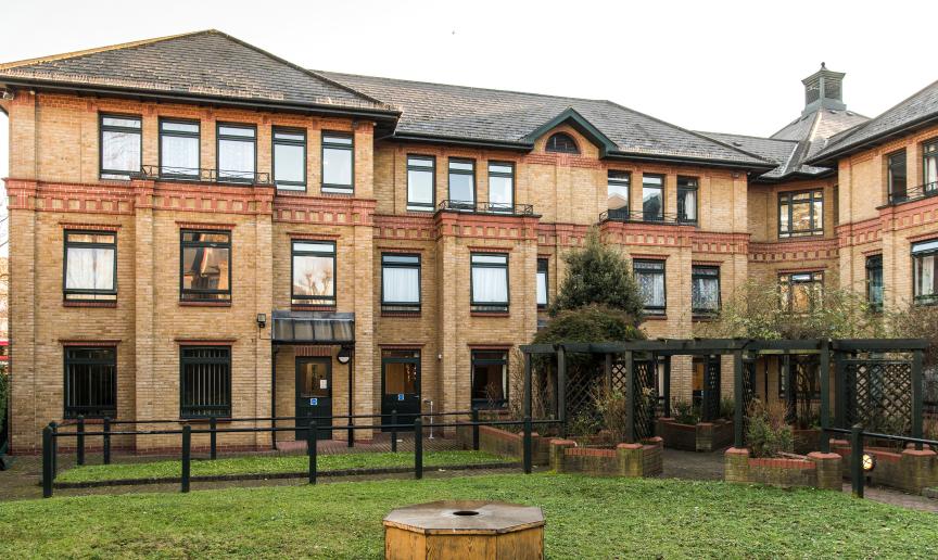 The characteristic, yellow brick built corner plot building, with a decorative red brick addition above the storey elevation wrapping the property and a magnitude of dark framed windows decorating the exterior. The centre of the property holds a well-maintained grassed area with brick paved walkway, as well as wooden pergola covering the entranceways into the property.