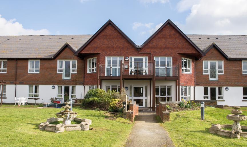 The beautiful two-storey property is designed with the ground floor covered in white render and the first floor in traditional red brick. The entrance is accessed by a pathway leading you through the grassed areas and stone water features either side of the walkway.