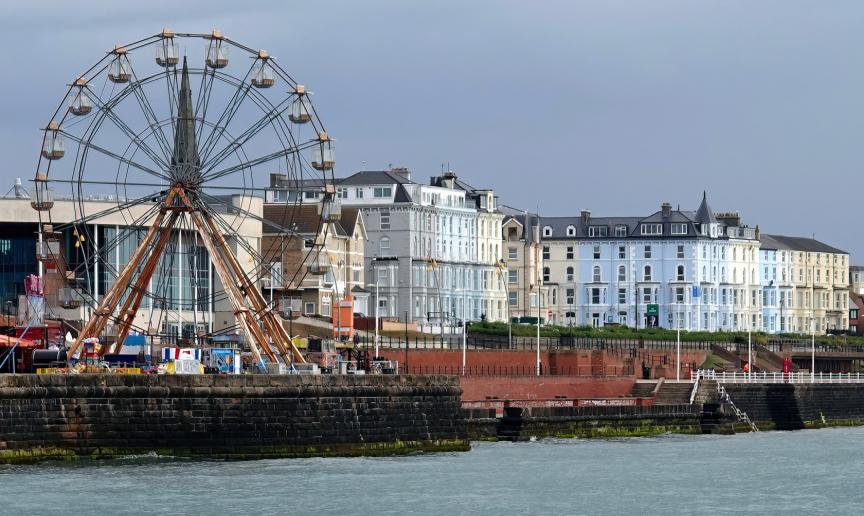 Red and white Ferris wheel located on the pier over looking the beachfront and sea. 