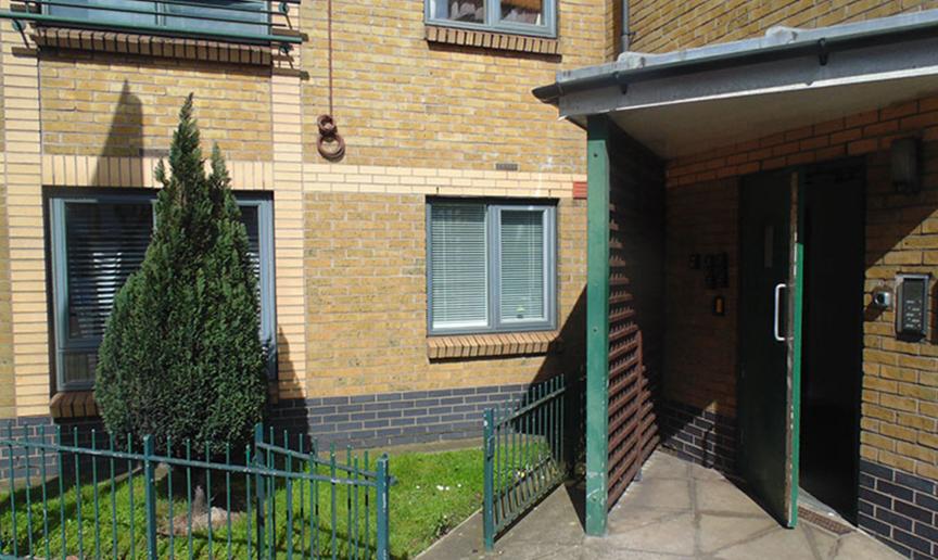 Yellow brick built supported living property with canape sheltering above the entranceway. 