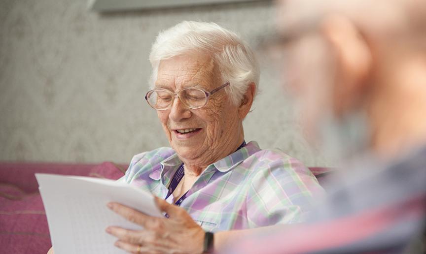 Resident sitting on a sofa while reading