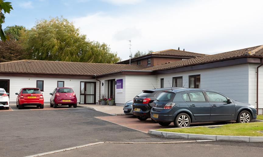 White wood panelled, single storey exterior at the residential care home Shaftesbury Court.