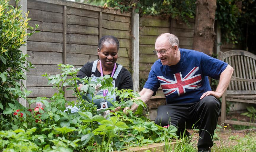 Staff and customer gardening together