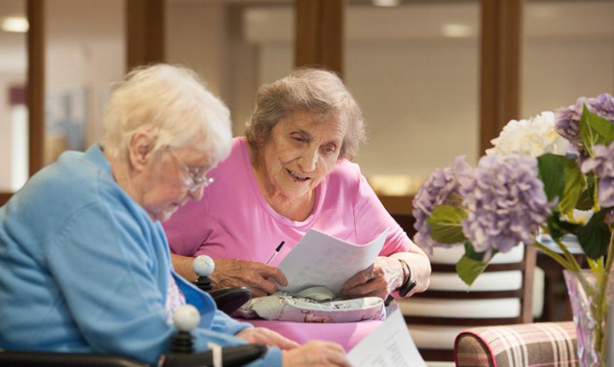 Supported living customers reading at a local service