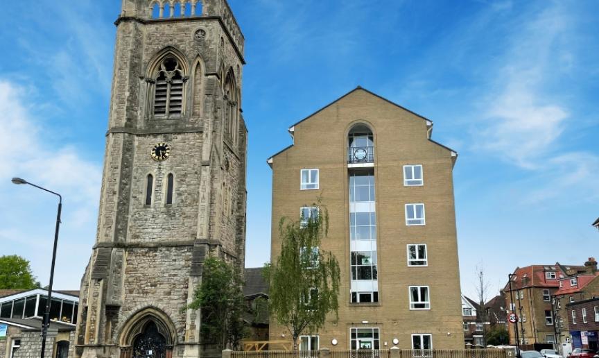 A multistory building next door to a church