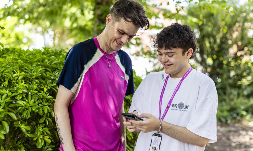 A staff member and a resident looking at phone and smiling