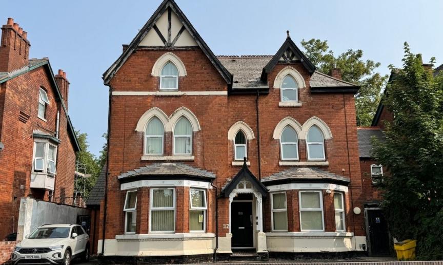 Exterior view of Sandwood House, a red brick supported accommodation property with period architectural features.