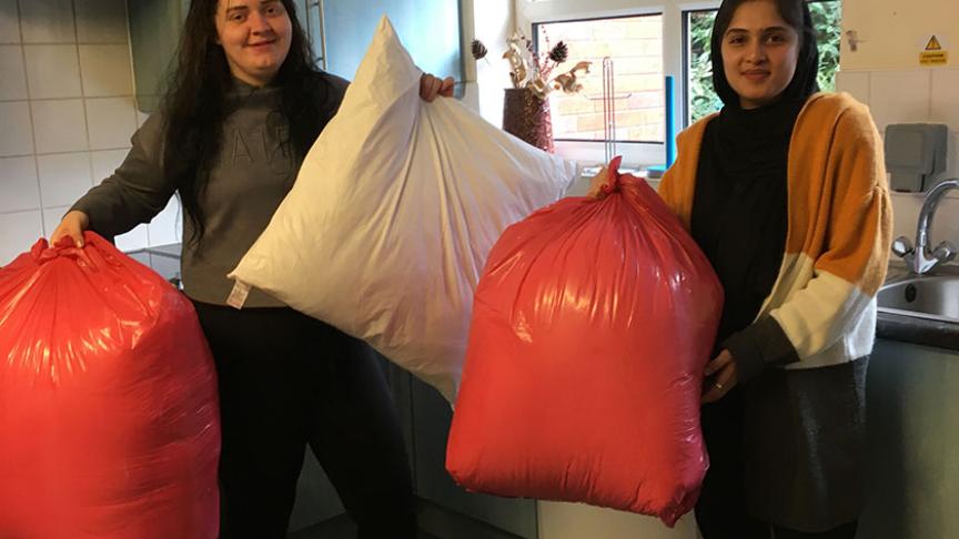 Residents hold the bags of donated pillows