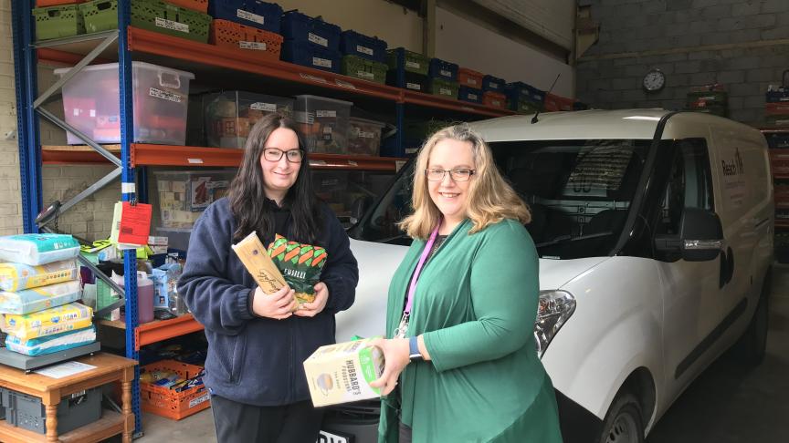 Foodbank Coordinator with Specialist Project Worker, hold donations and stand in front of a Foodbank van