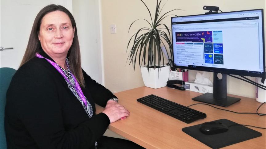 Local Service Manager, sitting at her desk facing away from her computer screen towards the camera