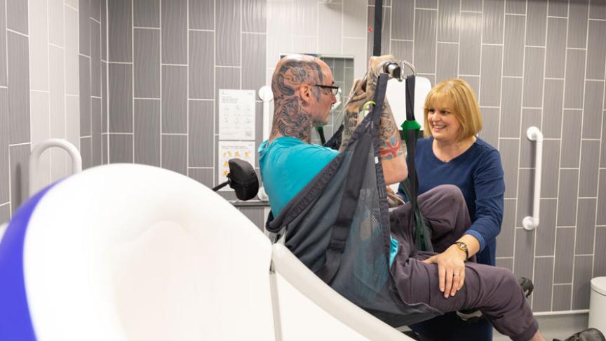 Award winning service manager using a hoist to lift a resident at Trowbridge