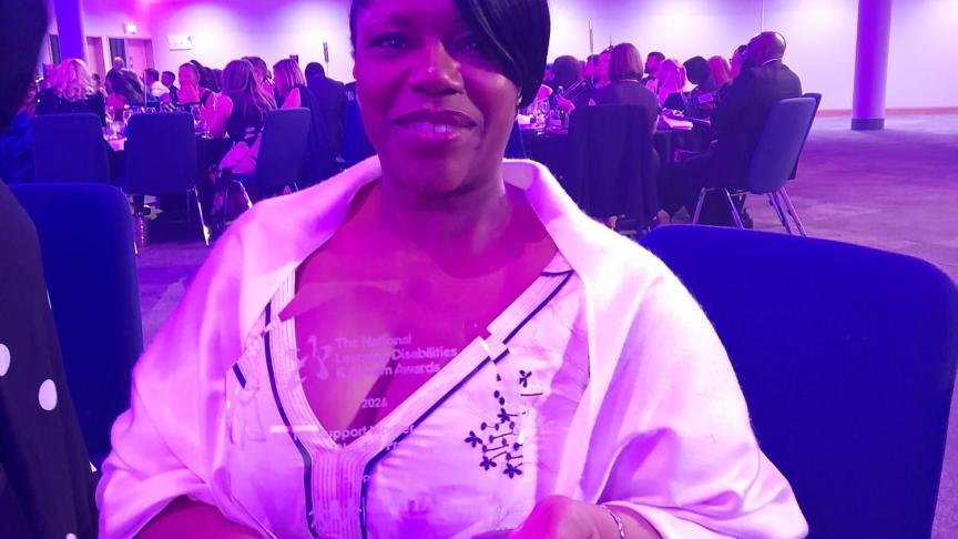 Lynn Clarke holding her award and smiling at the National Learning Disabilities and Autism Awards event
