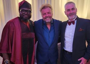 Local Service Manager at Sarnes Court, with host Martin Roberts and Dave Shaw stood smiling wearing smart clothes celebrating their success