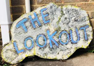 A log sign reads "The Lookout" in blue paint