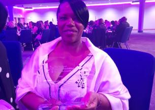 Lynn Clarke holding her award and smiling at the National Learning Disabilities and Autism Awards event