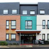 Modernised exterior with a mixture of building materials ranging from, brick, wooden panelling, coloured cladding and painted render create a bright impression of the property.