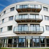Uniquely curved retirement living property. The building features an array of oversized windows and french doors as well as personal balconies for a bit of personal outdoor space.