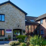 A stunning blend of stone materials for the façade of the entrance to Harry Garrett Court, the dark wooden framed window and doors contrast beautifully, to the left there is a wonderful floor to ceiling walkway linking to the traditional red brick extension. The well maintained gardens guide you to the entranceway in an inviting manner.