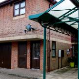 Large brick facility with dropped curbed access points and stepless entry. Providing onsite parking and twelve one-bedroom flats at Hilltop House. 