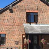 Conventional brick building, with weathering on the porch roof tiling at the supported care facility at the Old Milton Road Flats.