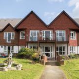 The beautiful two-storey property is designed with the ground floor covered in white render and the first floor in traditional red brick. The entrance is accessed by a pathway leading you through the grassed areas and stone water features either side of the walkway.