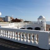 Stand out brilliant white pavilion, contrasting with the dark coloured beachfront and pale blue sea. 