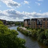 Tranquil curved canal, with modern new build five storey waterfront properties. 