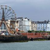 Red and white Ferris wheel located on the pier over looking the beachfront and sea. 
