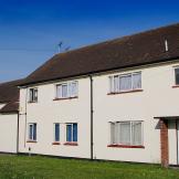 White rendered semi-detached home with manageable grassed front garden and car parking.