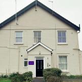 Large semi detached white rendered supported living property.