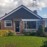 Peaceful bungalow property in Gleneagles Close with single storey extension to the right of the building. Behind a well-kept front garden and curved pathway.