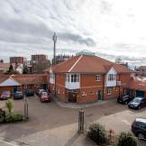 External image of Montague Road Care home, with a car park in front of the large building and high rise buildings in the distance
