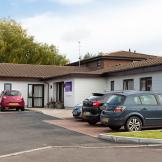 White wood panelled, single storey exterior at the residential care home Shaftesbury Court.