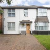 Grandiose white rendered detached home, with elongated driveway and grassed perimeter.