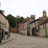 Supported Housing: Old stone brick built terraced properties built into a steep hill incline hill, the street is lined with old style metallic street lighting.  