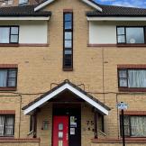 Exterior image of Cleve's Road a 3 story building with a bright red door 