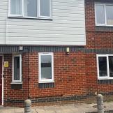 Exterior of a red brick building with black brick and white panelling accents