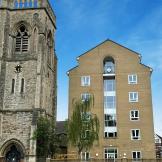 A multistory building next door to a church