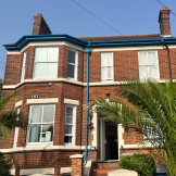 Exterior shot of brick built accommodation with large trees on the front 