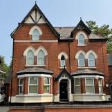 Exterior view of Sandwood House, a red brick supported accommodation property with period architectural features.